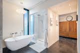 Aquabrass soaking tub, rain shower, heated towel rack, hidden ventilation fan, glass door and strip drain set in top end tile.