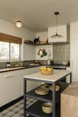 The kitchen and bathrooms have brass faucets sourced from Etsy seller BrassPure that will patina overtime. Ceramic dish wares and custom cabinets give the kitchen an earthly, lived in feeling.