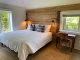 Bedroom, Rockers, Dresser, Bed, Light Hardwood Floor, Recessed Lighting, Ceiling Lighting, and Wall Lighting East wing master bedroom with locally sourced barn board wall feature.   Photo 5 of 11 in The Dainard Farmhouse 1825 by Andre Albinati