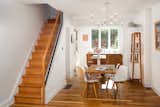 An exposed steel beam and brick wall separate the original footprint of the home from the addition. White oak floors warm the space.