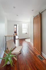 A custom white oak barn door conceals a walk in closet in the large open third floor bedroom.