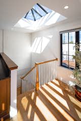 A gracious oversized skylight floods the staircase and lower levels with year-round daylight. The fully equipped service kitchen at the top of the stairs serves the roof deck.