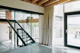 Lycos House's three levels and mezzanines are connected by a geometric green steel staircase custom designed by Atelier Manus.