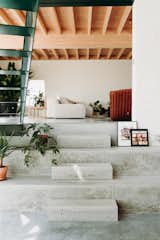 Rough elements like concrete floors and steel stairs mix with warmer materials to create balance and harmony.