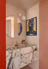In the ensuite, the GLO-BALL wall lamp, a Jasper Morrison design for FLOS, and Study faucet by TRES over the bespoke marble basin.