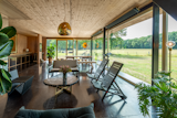 Belgian furniture makers Woodspot created a custom coffee table out of petrified wood and chairs that playfully echo The Chairhouse. A Tom Dixon lamp draws the eye upward.