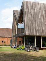 The Chairhouse (Villa Tellier) by ABN Architecten exterior with zigzag roof and off-road buggy parked