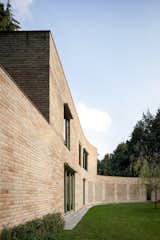 The curved brick wall was formed in relation to the pine forest on which the property is situated, and it continues throughout the main residence as an interior partition.