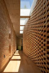 Fluidity and natural light characterize the central walkway that connects the main residence's living spaces.