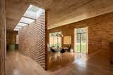 A curving rammed concrete ceiling complements the wave of the latticed brick inner partition. 