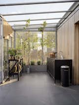 View into the rooftop greenhouse with its outdoor kitchen and pedal bin from Vipp.