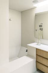 A geometric bath in crisp off-white tones offers a sanctuary within a sanctuary.