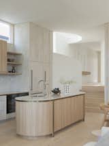 Warm curves resound throughout the kitchen, offsetting the angularity of the bungalow's original pitched rooves.