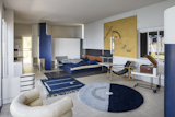 The living room was restored with sea-inspired furnishings including a large nautical map and a low-slung Transat chair that Gray designed based on the deck seating on transatlantic cruise ships. Deep-blue accents mark the rugs, daybed, and room dividers.