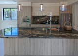 Kitchen of back townhome includes ten foot island and dramatic quartzite counter and backsplash