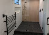 Steam Shower with wood look tile, black pebble floor and heated towel rack.