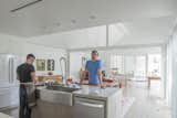 Ben Koush and Luis de las Cuevas stand at the island in their sleek and modern kitchen, which looks upon the dining room and living room in one open floor plan. 