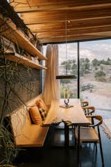 Dining area detail with built-in banquette perched over the pond. Pendant lights by Blu Dot.

