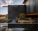 Dyed to match the area’s natural black boulders, the mass wall extends 20 feet beyond the home’s exterior to create a private bathing courtyard, sheltered from prevailing winds. 

