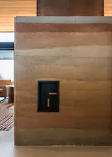 You'll find the fireplace controls built right into the side of the rammed-earth hearth. 