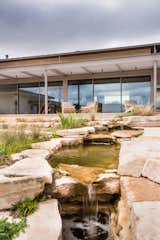Jobe Corral Architects River Ranch house landscaping, with custom water feature surrounded by limestone.