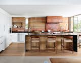 Jobe Corral Architects River Ranch house kitchen with rammed-earth wall and copper hood vent.