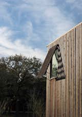 The rhythm of the slat wall (made from red cedar and stained to look prematurely weathered)  is echoed in the shutter detailing on each window. 