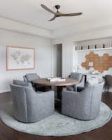 A desk along the wall is for computer work, but a communal round table in this home office by Bandd Design is a great place for kids to work on art projects or handwritten assignments in comfy chairs. 