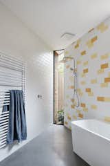 The subway tiles in the bathroom echo the pattern of the bricks elsewhere in the house. Strategically placed windows let the daylight flow in, even during bath time.