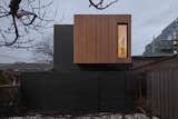 Darkened cedar siding gives the laneway house a polished presence.