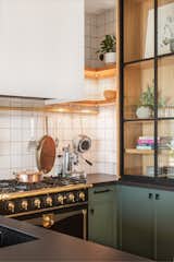 In the kitchen, mullioned glass cabinets showcase Isabella’s tableware and treasures, while a brass pot rail makes it easy to grab her cooking tools.