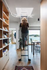 A rolling ladder gives Isabella access to the home’s high-up shelves. It also cleverly slides along a railing that leads to a rooftop deck overlooking the waterway.