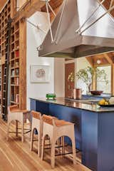 “When you're standing at this in the triangle of the oven-kitchen sink-counter area, you basically can see everything going on. You can see the pool, you can see out to the view, you can see people in the living room, so like it's like a killer central spot to sort of run the room,” says Natalie.  Lostine stools line the island; orange light sockets were sourced from the hardware store. 
