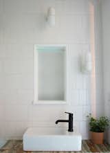In the bathroom, white subway tiles from Home Depot line the walls. The chic wall lights are just from Ikea. 