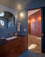 The bathroom is clad in blue penny tile, and natural light pours in to illuminate it all. “It’s almost a spa-like experience,” says Khoi. The tiles are from Bedrosians.
