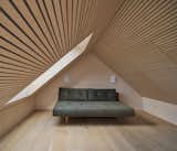 Timber slats line the ceiling, matching the wood tone of the floor and walls. 