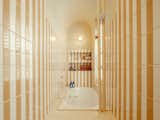 Perron rearranged the stairway to the condo to build a “cocoon-like bathroom” with a window in the back, she says; the sunken tub is the star of the show, but the butter-and-cream coloured tiles, arranged in a striped formation, are an inspiring supporting act. (“It’s my favorite room in the condo,” admits Perron.)
