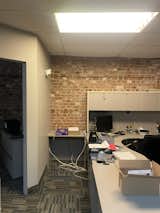 BEFORE: The brick was a hint this office space had good bones... if you could tear your eyes away from the fluorescent ceiling light.  Photo 23 of 40 in Before & After: This Color-Obsessed Quebec Designer Lives Above Her Studio