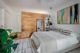 Behind the wood divider (also made from repurposed shiplap from the old design) is an extensive closet area that leads into the ensuite.  Photo 9 of 10 in Budget Breakdown: A Butter-Yellow, Swooped-Roof Houston Home Gets a Secret Addition for $507K