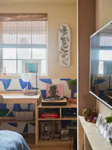 A skateboard hangs above a plywood desk filled with Will’s favorite records, books, and sports memorabilia.&nbsp;