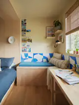 The built-in desk area features Concrete Collaborative's Dazzling Blue tiles running the length of the window, creating a vibrant backdrop that anchors the room's color palette.