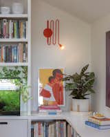 A Louis wall lamp in Blood Orange by Sara Shoenberger accents the library...as does the family’s prized saltwater fish tank. 