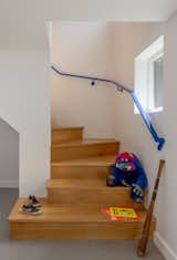 This staircase by Kable Design Build features white oak treads and a powder-coated steel handrail with a perforated metal guardrail by Seattle Metal Fabrication. 