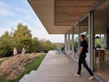 The wooden terrace spans the length of the house, connecting the building directly to the landscape.