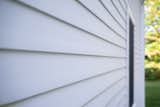 The hidden fastener system throughout the siding eliminates visible nail holes and plugs, maintaining clean sight lines.  Photo 5 of 7 in A Colonial-Style Home Gets a Second Life Without Losing Its Charm