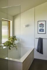 Pental tiles surround the tub and line the shelf in the ensuite. 