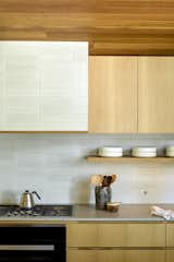 The tiles continue up onto the vent hood to enhance the room's textured look. 