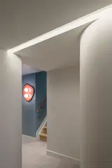 Curved corners lead the eye through the space, establishing a visual language that makes the apartment feel generous despite its modest square footage.