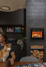 Mochi and Daren linger next to the Wittus 600 fireplace with Ann Sacks tile facing and custom steel surround, sides, liner and kindling shelf. This element was completed years after move-in as funds became available.