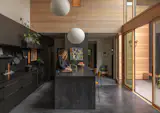 Stock Ikea flatpack cabinets in black look custom when paired with Richlite paper-resin backsplash and back counters. Bosch 800 Series appliances and an Imperial range hood handle cooking duties.